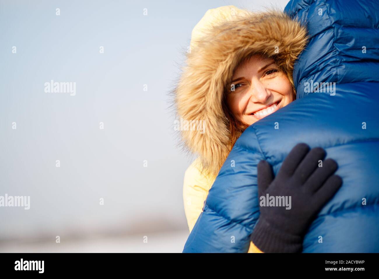 Felice coppia di maschio e femmina abbracciando ain inverno all'aperto Foto Stock