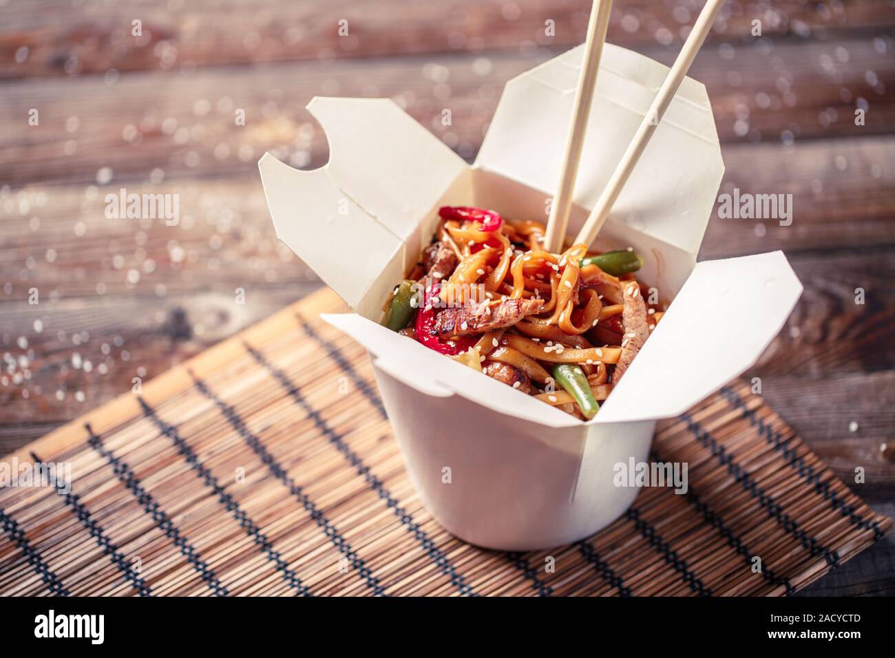 Tagliatelle con carne di maiale e le verdure in take-out box sul tavolo di legno Foto Stock