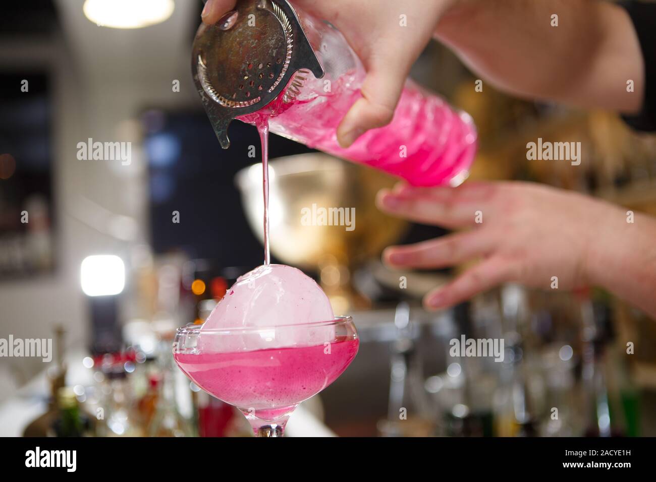 Close-up di barman versa manualmente rosa cocktail drink nel bar Foto Stock