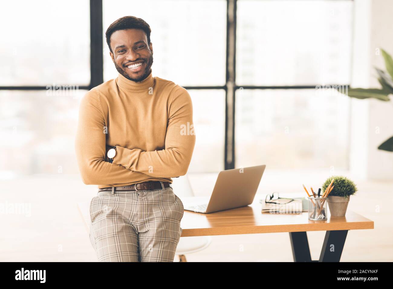 Nero di successo uomo seduto sulla scrivania in ufficio Foto Stock