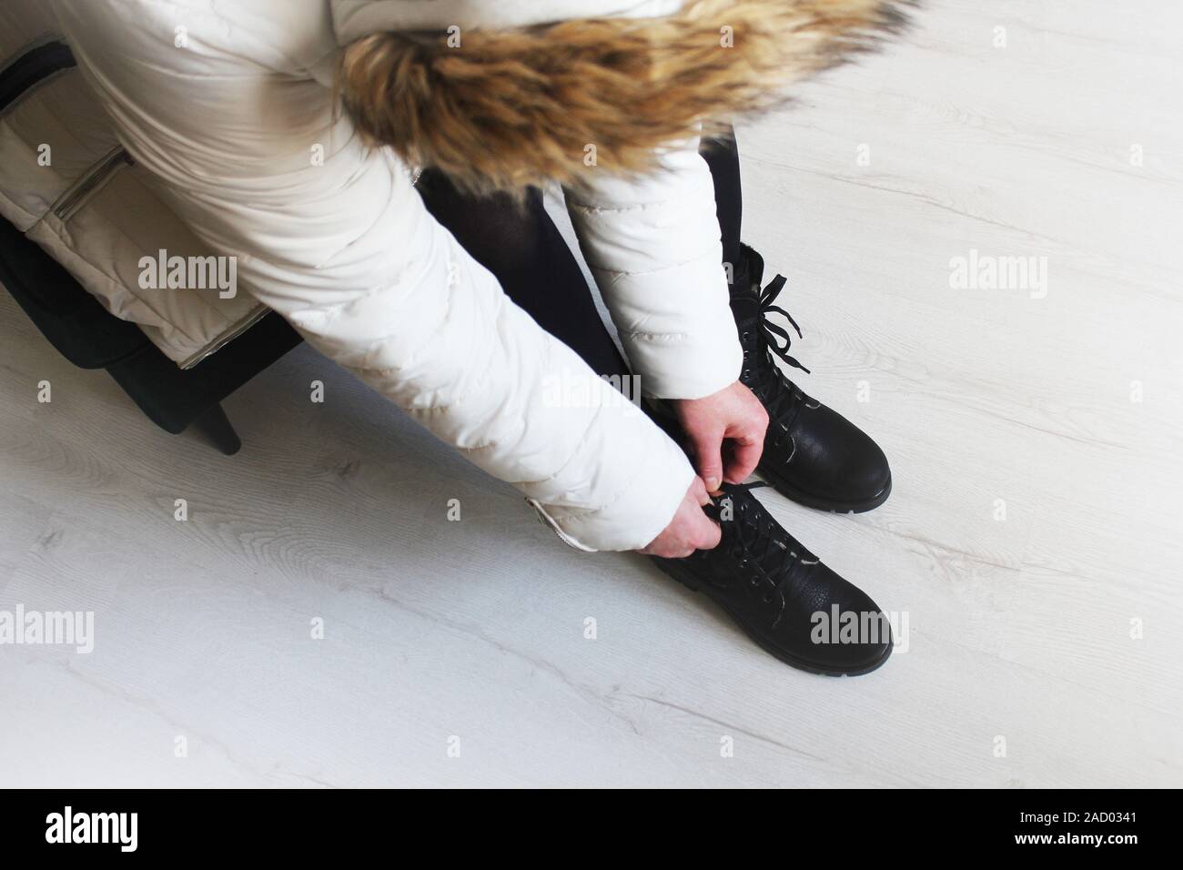 Ragazza mette su scarponi in una calzatura store. Dimostrazione di Donna stivali. Acquisto di scarpe di stagione Foto Stock