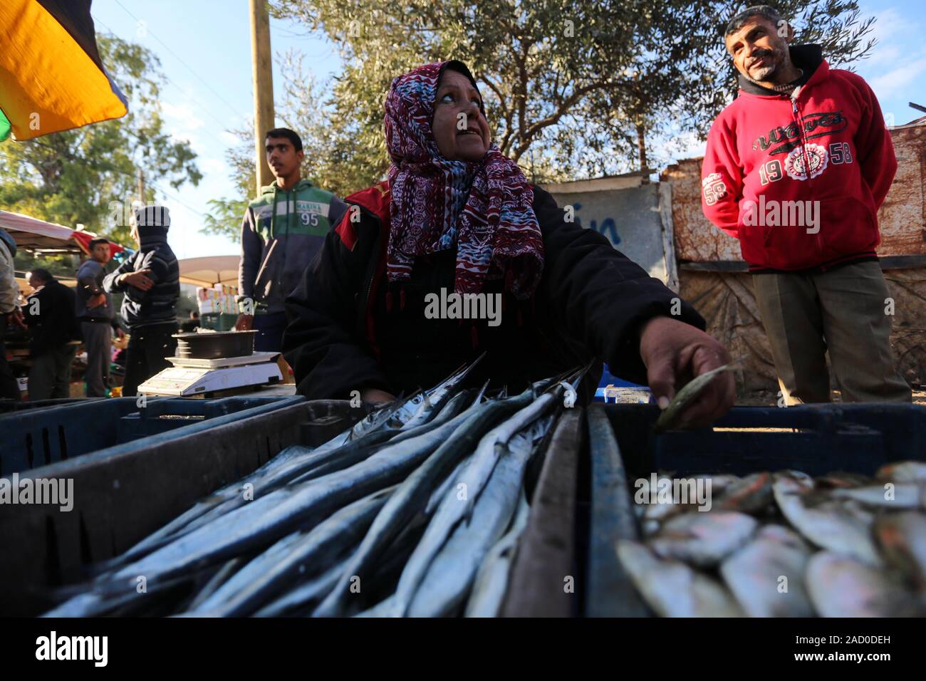 Deir Al Balah, Striscia di Gaza, Territori palestinesi. 3 dicembre, 2019. Fisherwoman palestinese Um Jimal al-Akra, la vendita del pesce in un mercato di Gaza City, sul dicembre 03, 2019. Dopo che lei ritorna a Gaza City con pesce, Um Jimal compete con altri operatori di mercato del pesce a Deir Al Balah distretto, dove la più importante fonte di vita è la pesca industria: Credito Ashraf Amra/immagini APA/ZUMA filo/Alamy Live News Foto Stock