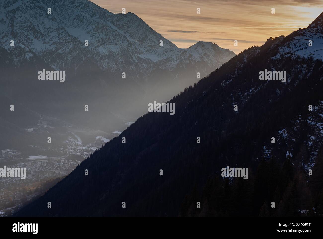 Montagne impilati in Francia con il sole in arrivo tra di essi e inserendo la valle. Il foreround è una sillhouette Foto Stock