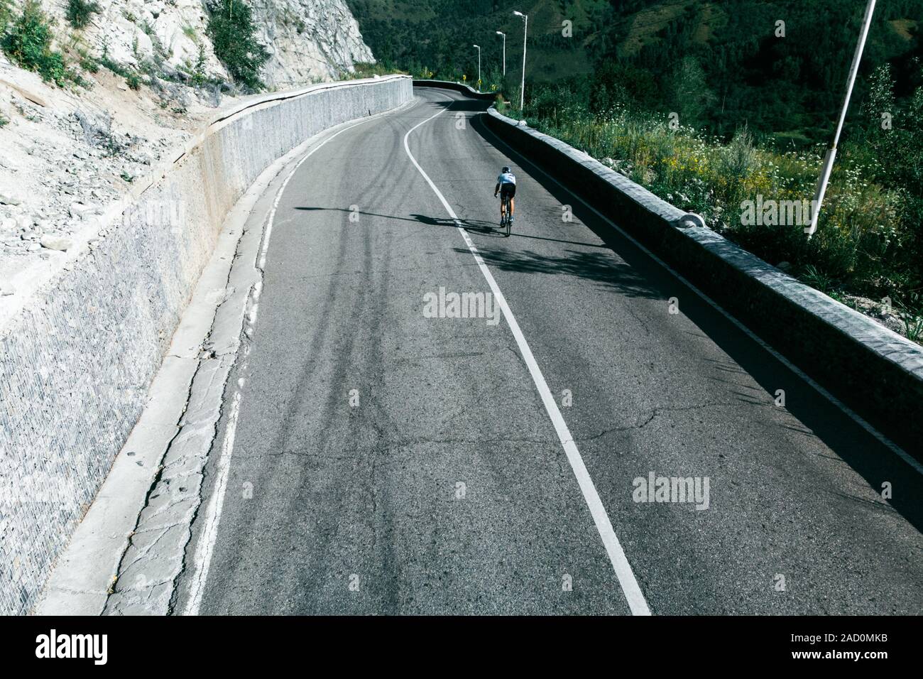 L'uomo è in sella ad una bicicletta. Una montagna di strada a serpentina. Il Kazakistan, Almaty, Medeo Foto Stock