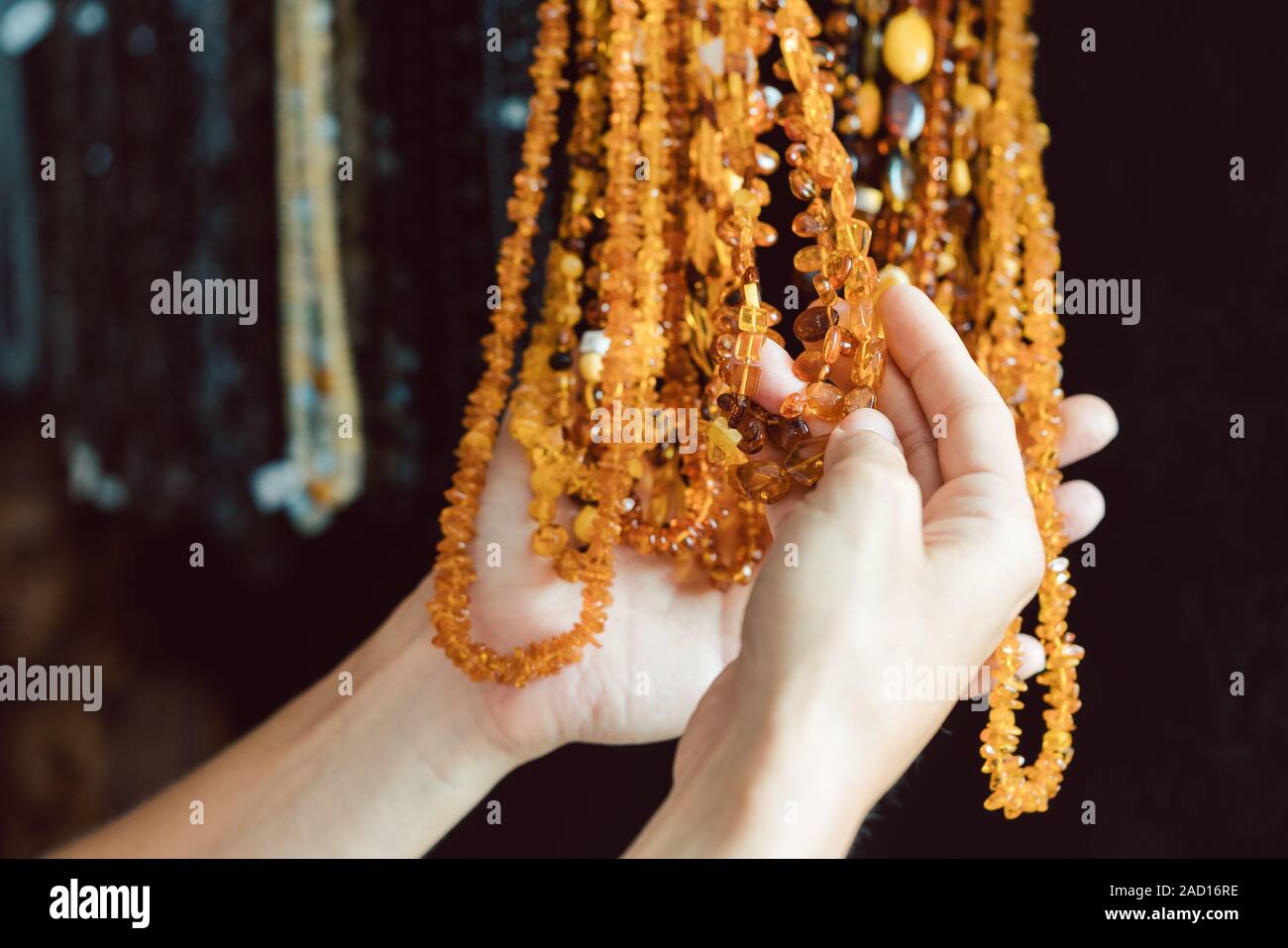 Donna che guarda ad una collana di ambra Foto Stock