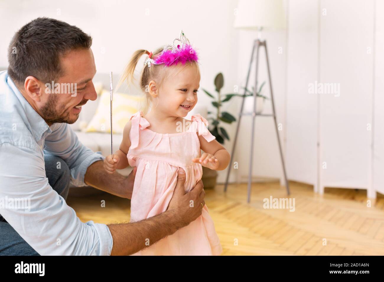 Carino figlia con la bacchetta magica giocando con il padre Foto Stock