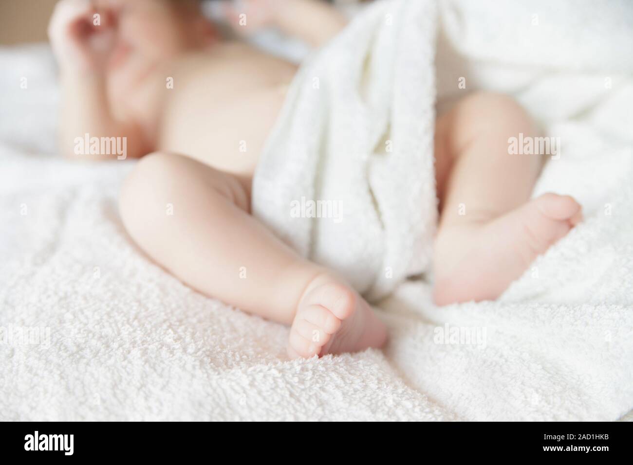 Neonato neonato sdraiato sul letto con coperta Foto Stock