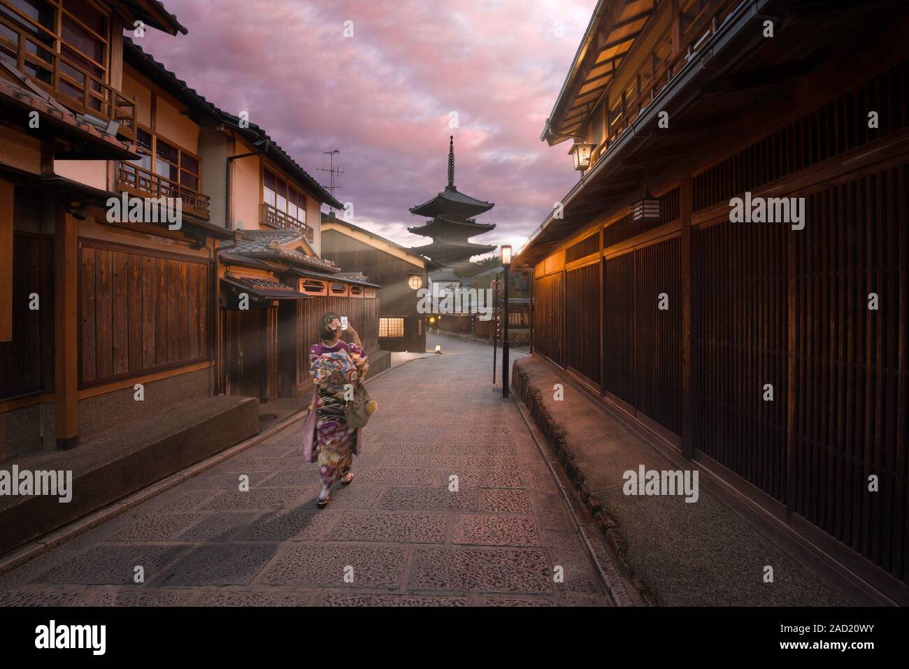 Kyoto, Giappone - 4 Novembre 2018: una donna vestita come una Maiko di scattare una foto di Yasaka Pagoda con raggi del sole all'alba in Gion, Kyoto Foto Stock