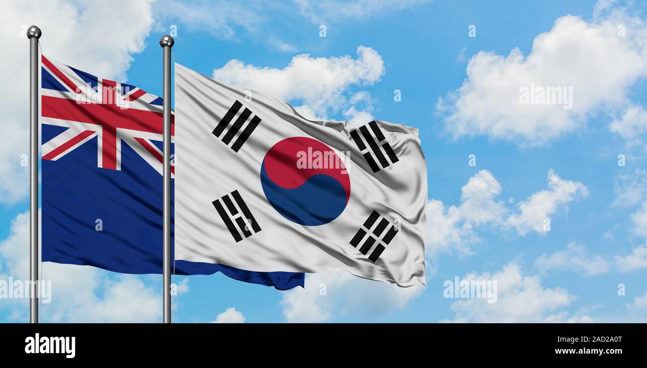 La Nuova Zelanda e la Corea del Sud bandiera sventolare nel vento contro bianco torbido cielo blu insieme. Concetto di Diplomazia e relazioni internazionali. Foto Stock