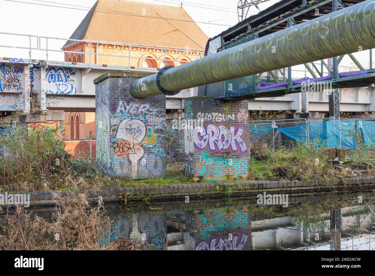 Graffiti dipinta su un muro di mattoni da un ponte sopra il Worcester e Birmingham canal in Selly Oak, Birmingham, Regno Unito Foto Stock