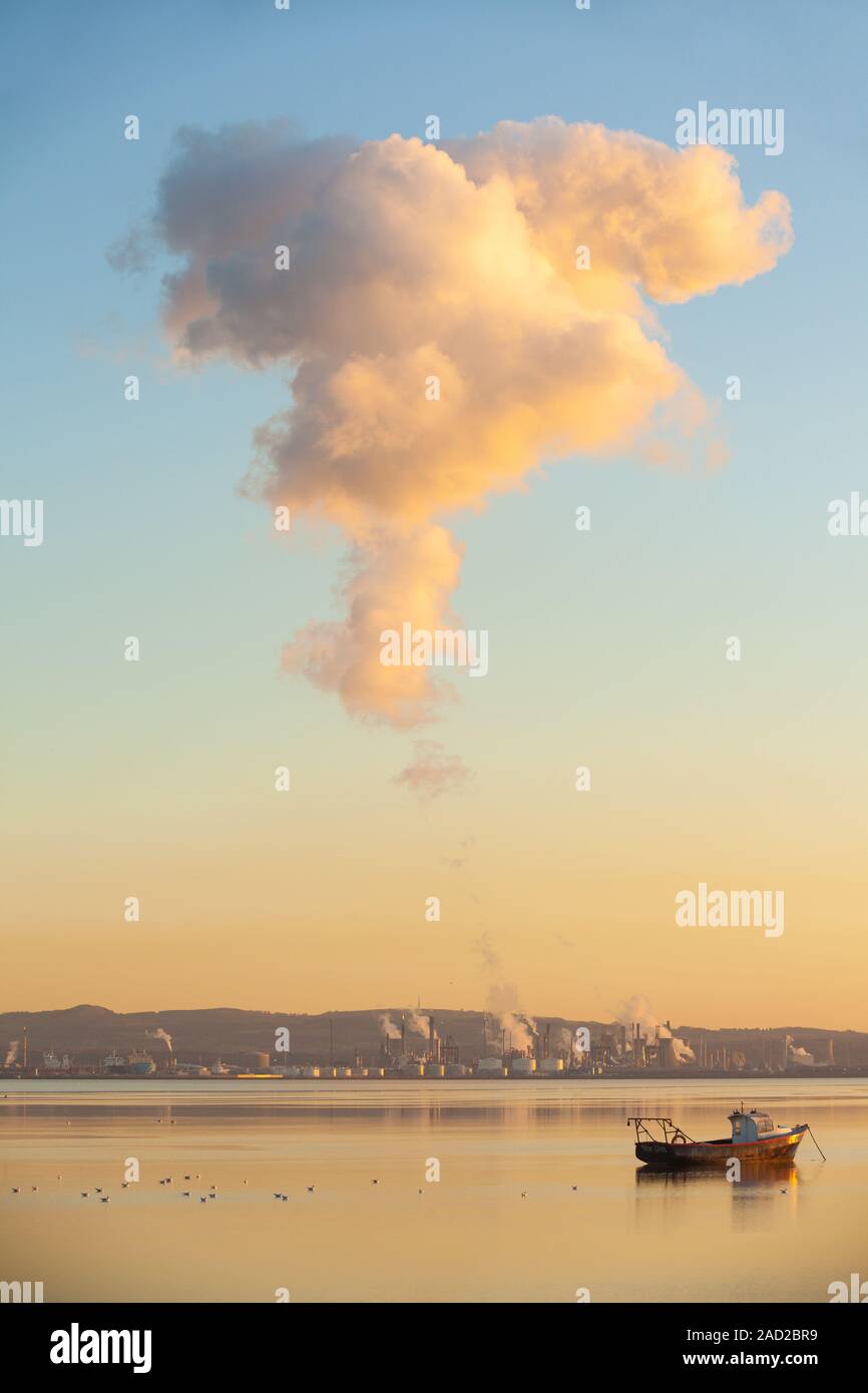 La formazione di nubi oltre le torri di raffreddamento di Grangemouth raffineria di petrolio con con il fiume Forth in primo piano. Foto Stock