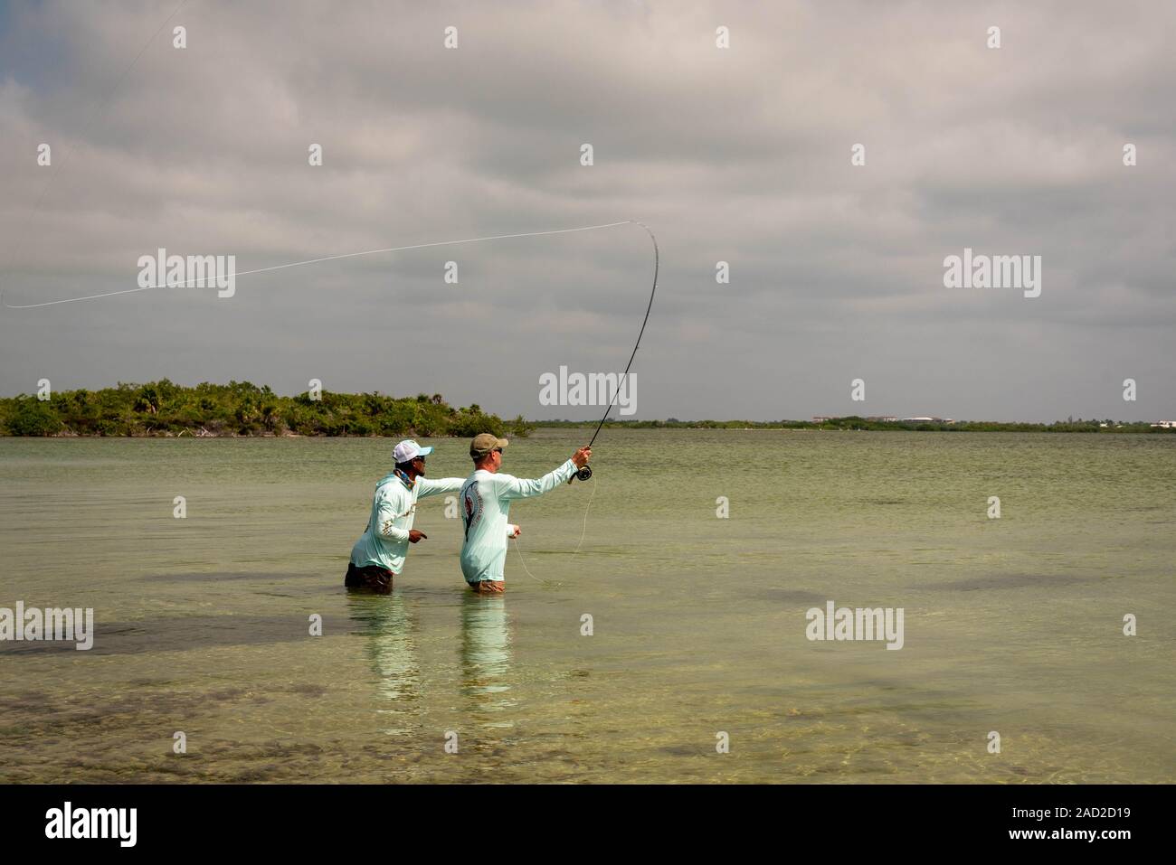 Ambergris Caye Belize - Novembre, 16, 2019. Un Belizean guida di pesca sottolineando la scuola di bonefish sulle parti piatte sulla piccola isola dei Caraibi. Foto Stock