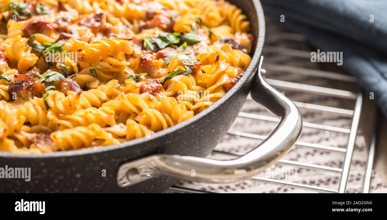Pasta al forno fusilli con carne di maiale affumicato collo formaggio mozzarela e altri ingredienti Foto Stock