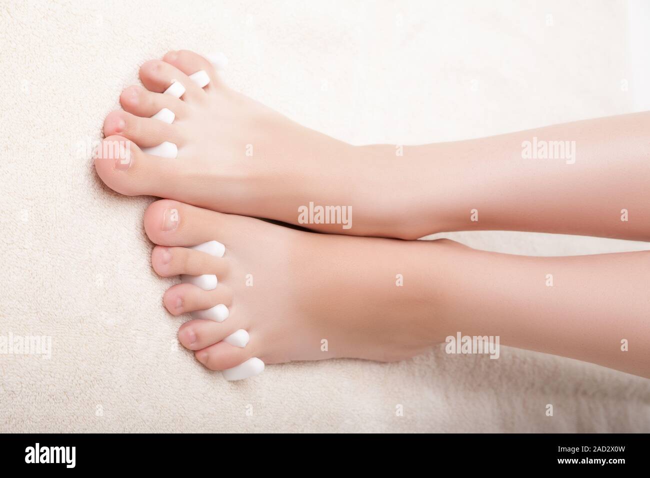 Piedi pedicure applicando una donna in piedi in separatori di punta Foto Stock