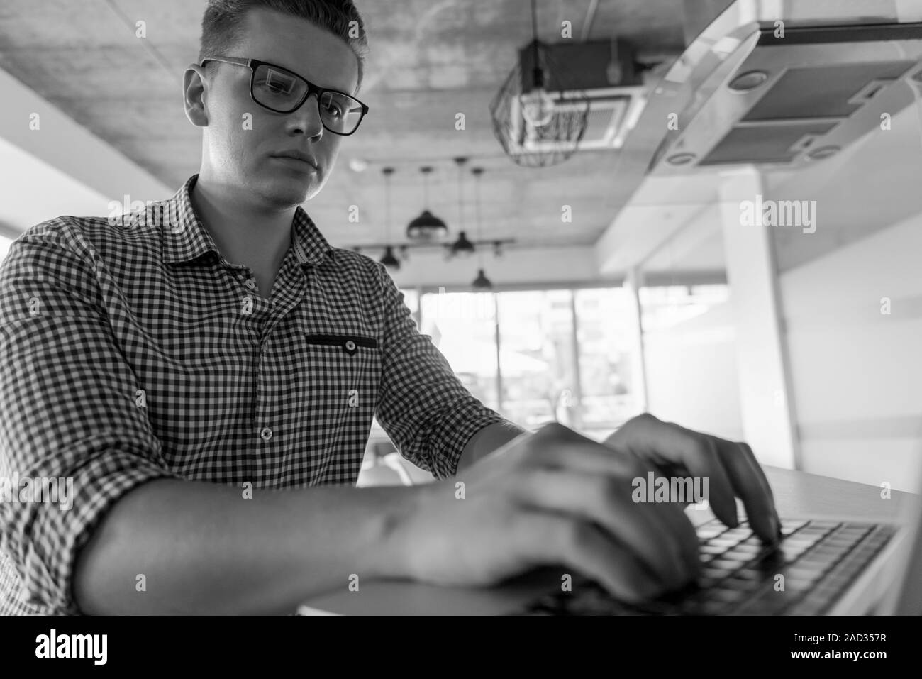 Giovane uomo che lavora sul computer portatile Foto Stock Giovane uomo che lavora sul computer portatile Foto Stock