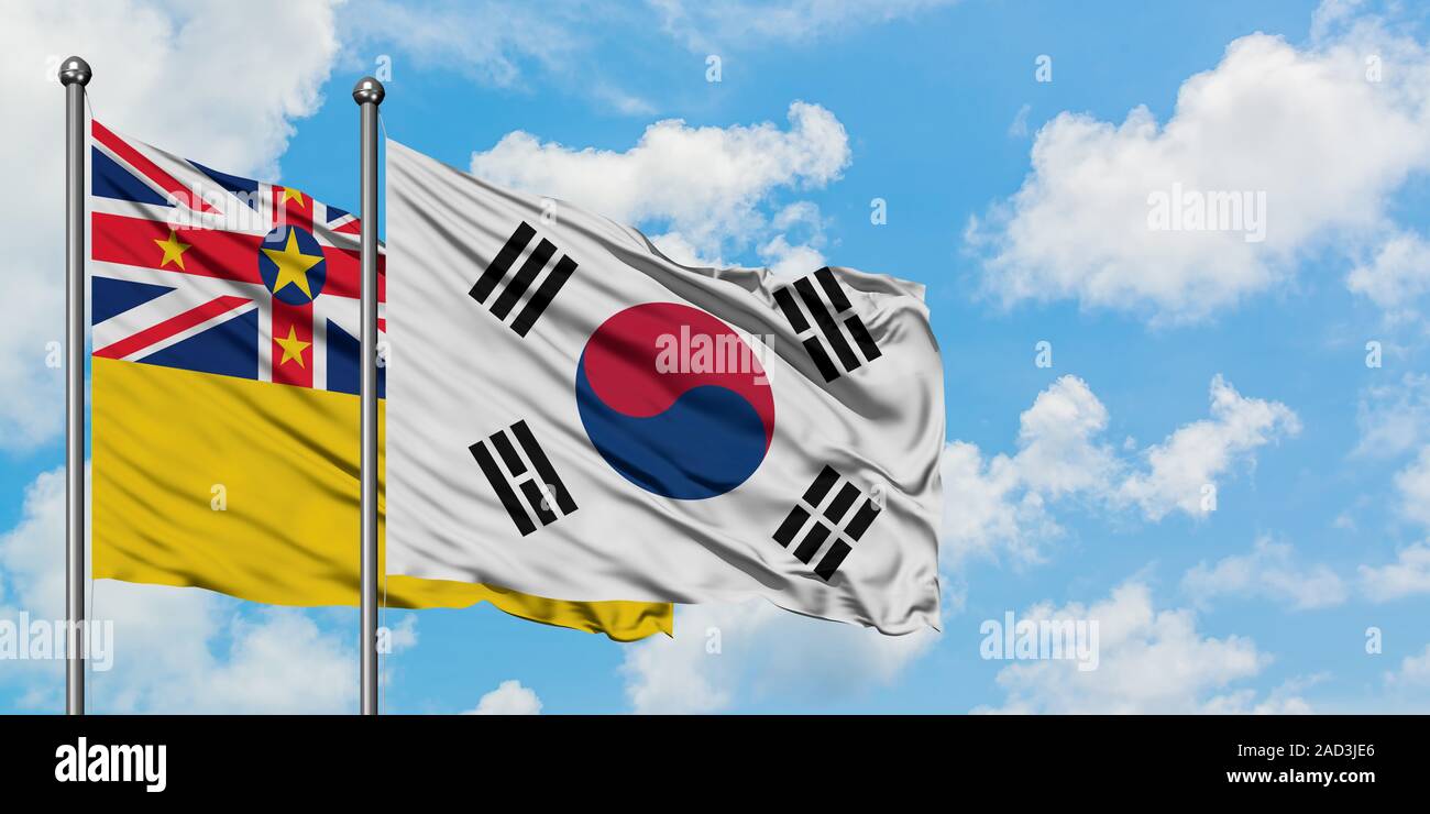 Niue e Corea del Sud bandiera sventolare nel vento contro bianco torbido cielo blu insieme. Concetto di Diplomazia e relazioni internazionali. Foto Stock