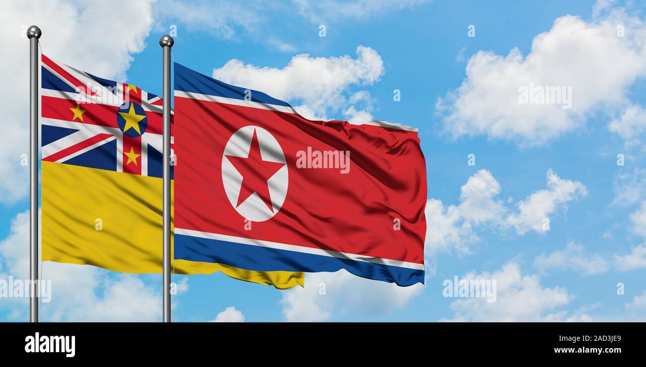 Niue e Corea del Nord bandiera sventolare nel vento contro bianco torbido cielo blu insieme. Concetto di Diplomazia e relazioni internazionali. Foto Stock
