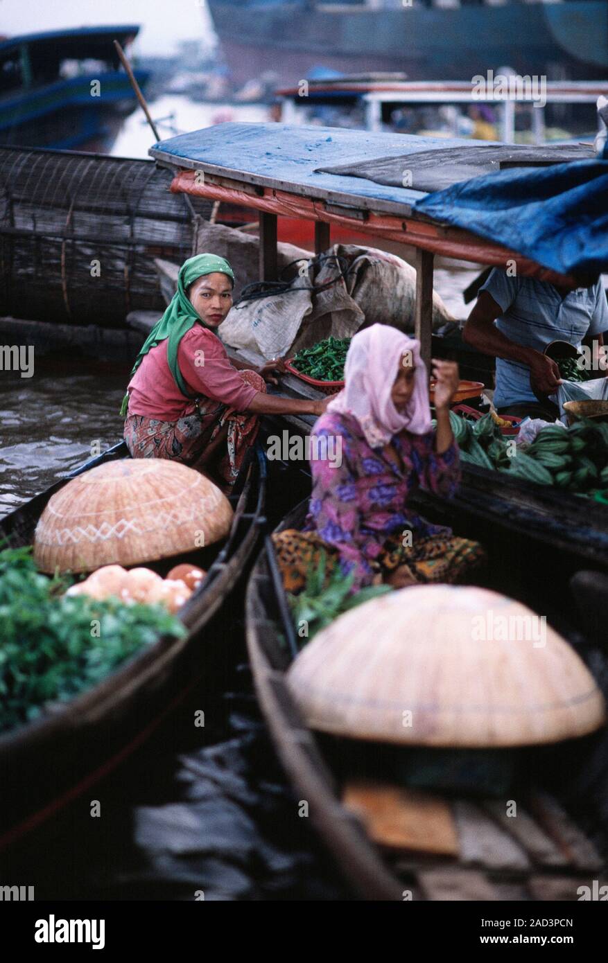 Indonesia. Borneo. Kalimantan. Mercato galleggiante. Le donne dei venditori di ortaggi in canoa. Foto Stock