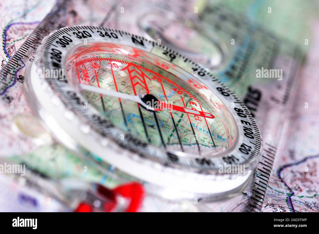 Bussola e mappa. La bussola ha una libera oscillazione di ago magnetico (rosso/bianco) rivolti ad un quadrante. Il quadrante è graduato in gradi e mostra la cardin Foto Stock