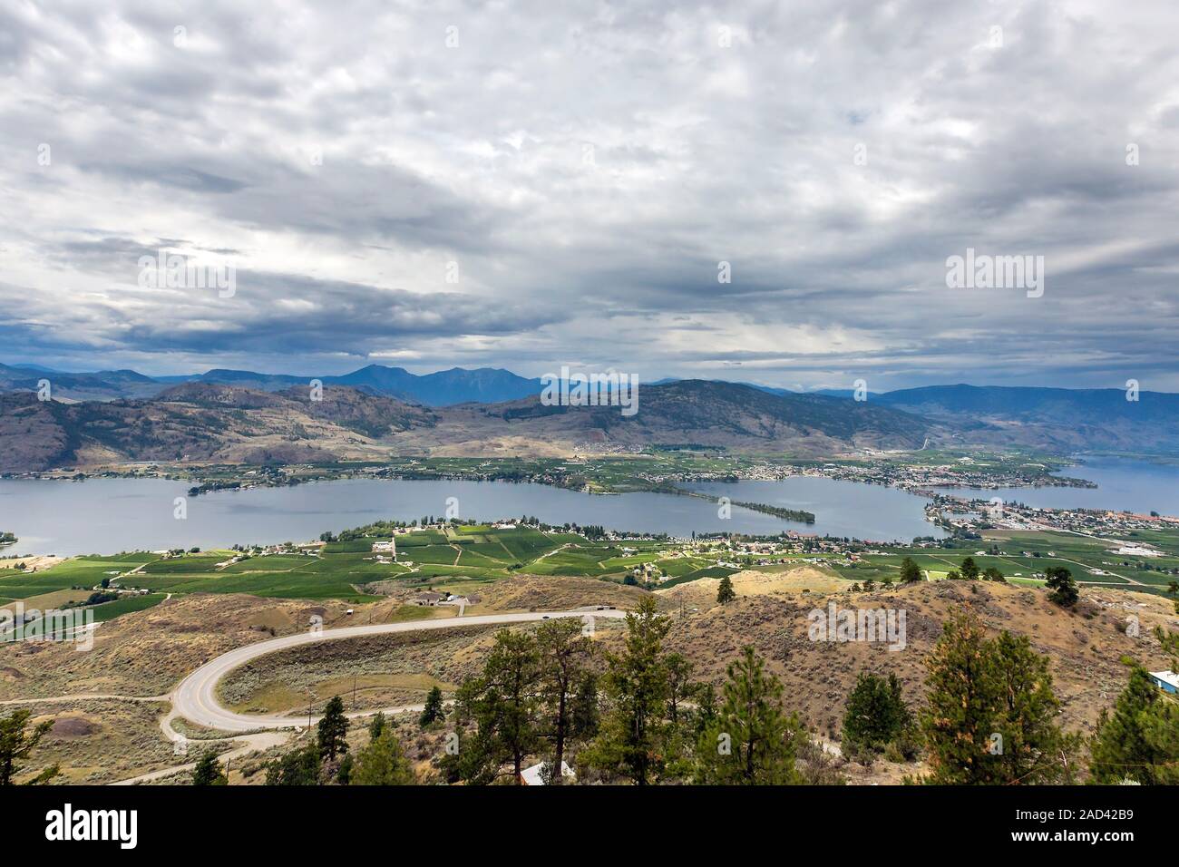 Vista panoramica da Osoyoos lookout point sulla città di Osoyoos, Osoyoos Lake, vigneti, fiume, cielo nuvoloso. Okanagan, British Columbia, Canada Foto Stock