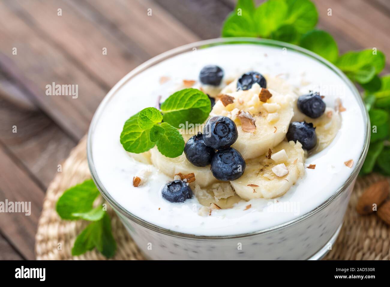 Yogurt con mirtilli freschi, banana e mandorla dadi, deliziosi dessert per una sana prima colazione Foto Stock