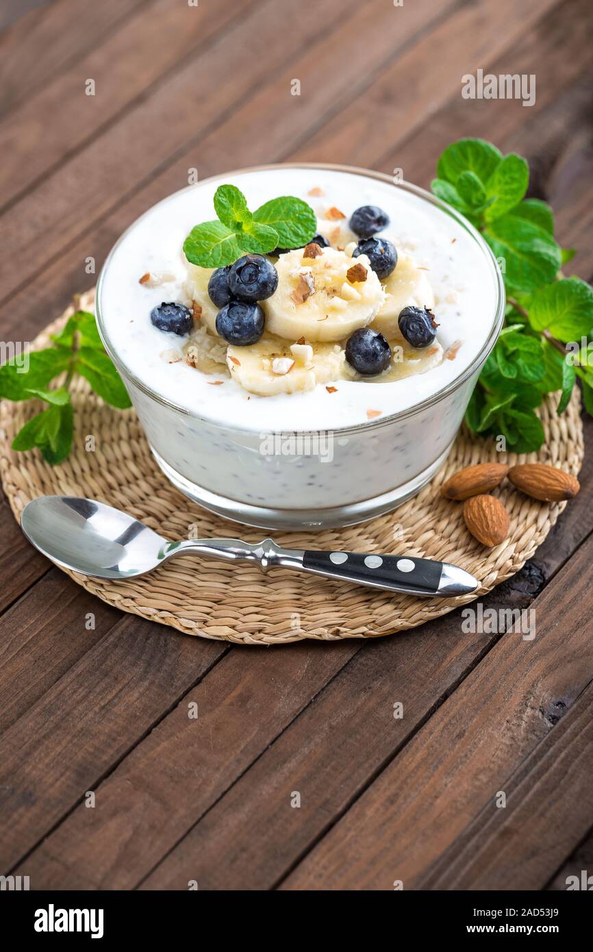 Yogurt con mirtilli freschi, banana e mandorla dadi, deliziosi dessert per una sana prima colazione Foto Stock