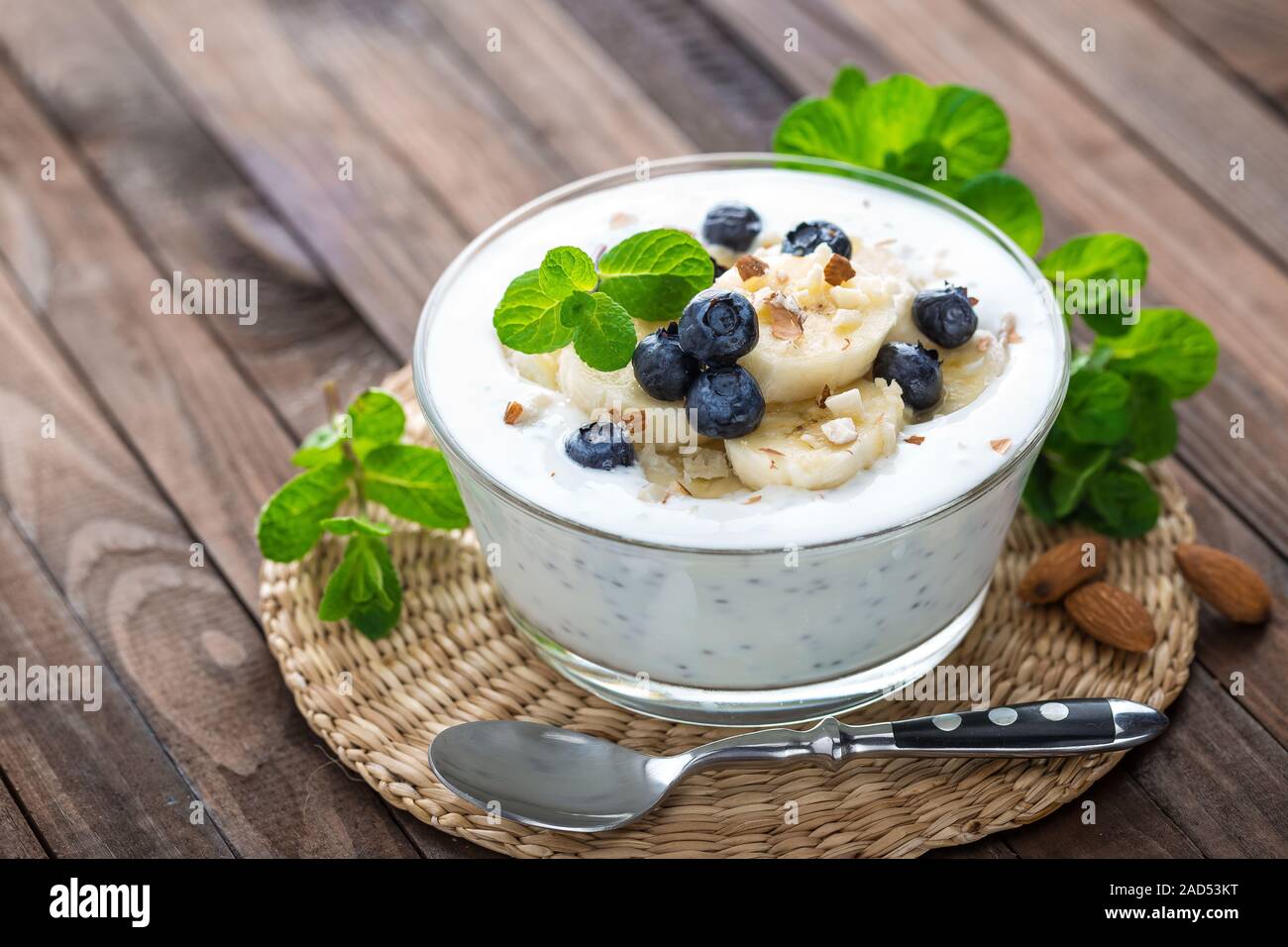 Yogurt con mirtilli freschi, banana e mandorla dadi, deliziosi dessert per una sana prima colazione Foto Stock