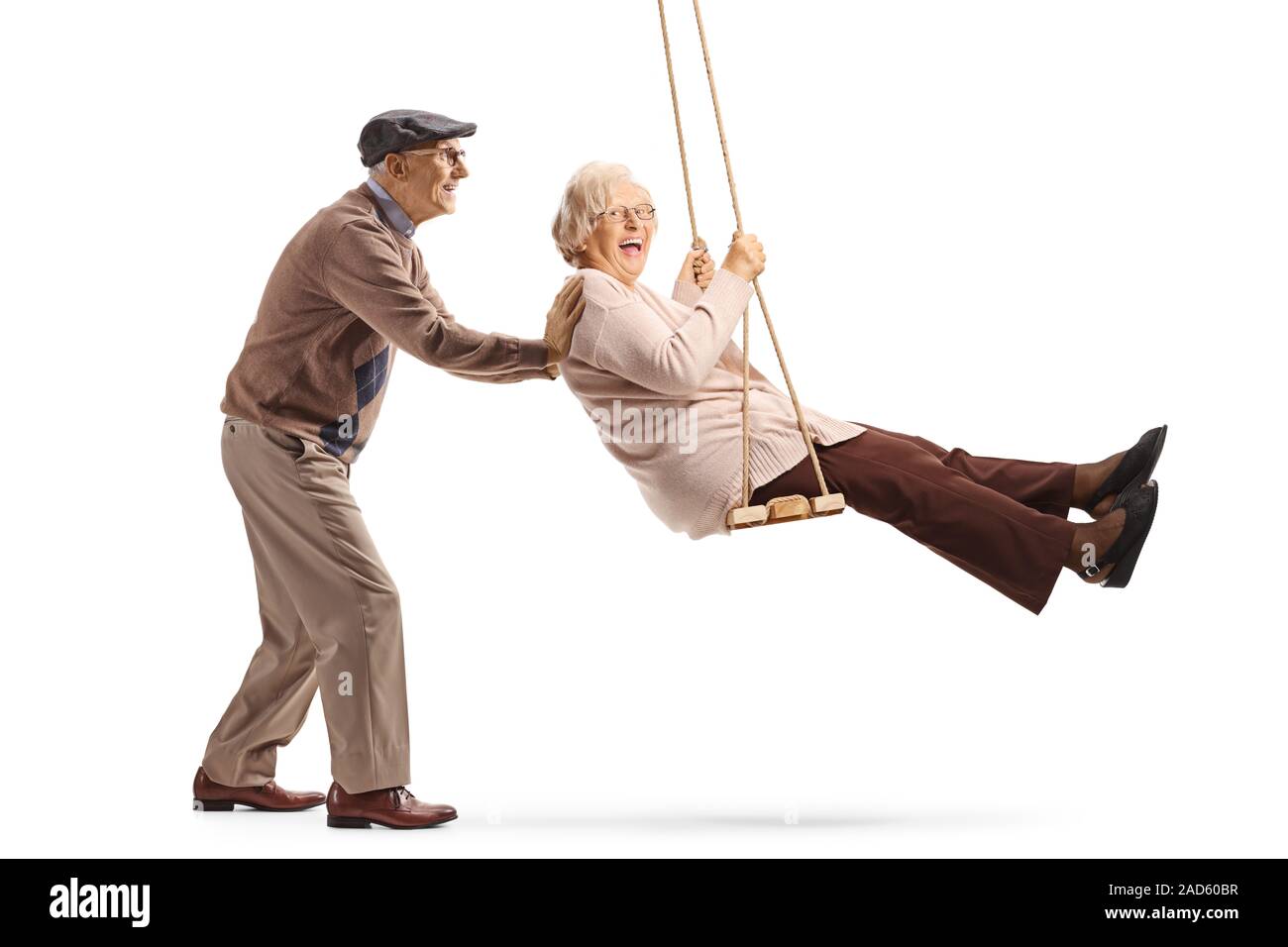 A piena lunghezza shot di un anziano uomo spingendo un senior donna su un altalena isolati su sfondo bianco Foto Stock