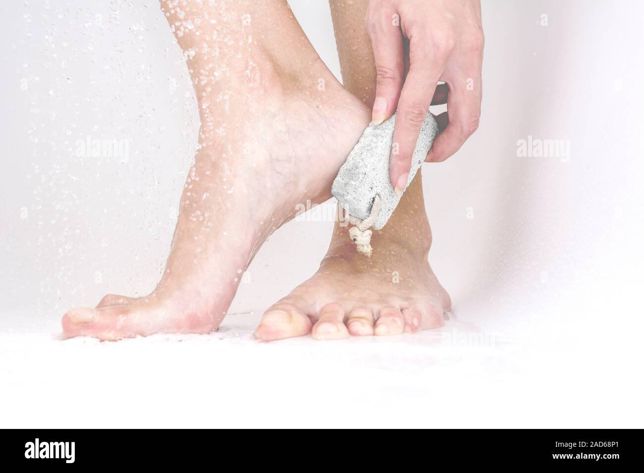 La donna lo strofinamento con pietra pomice per rimuovere la pelle morta  dai piedi Foto stock - Alamy