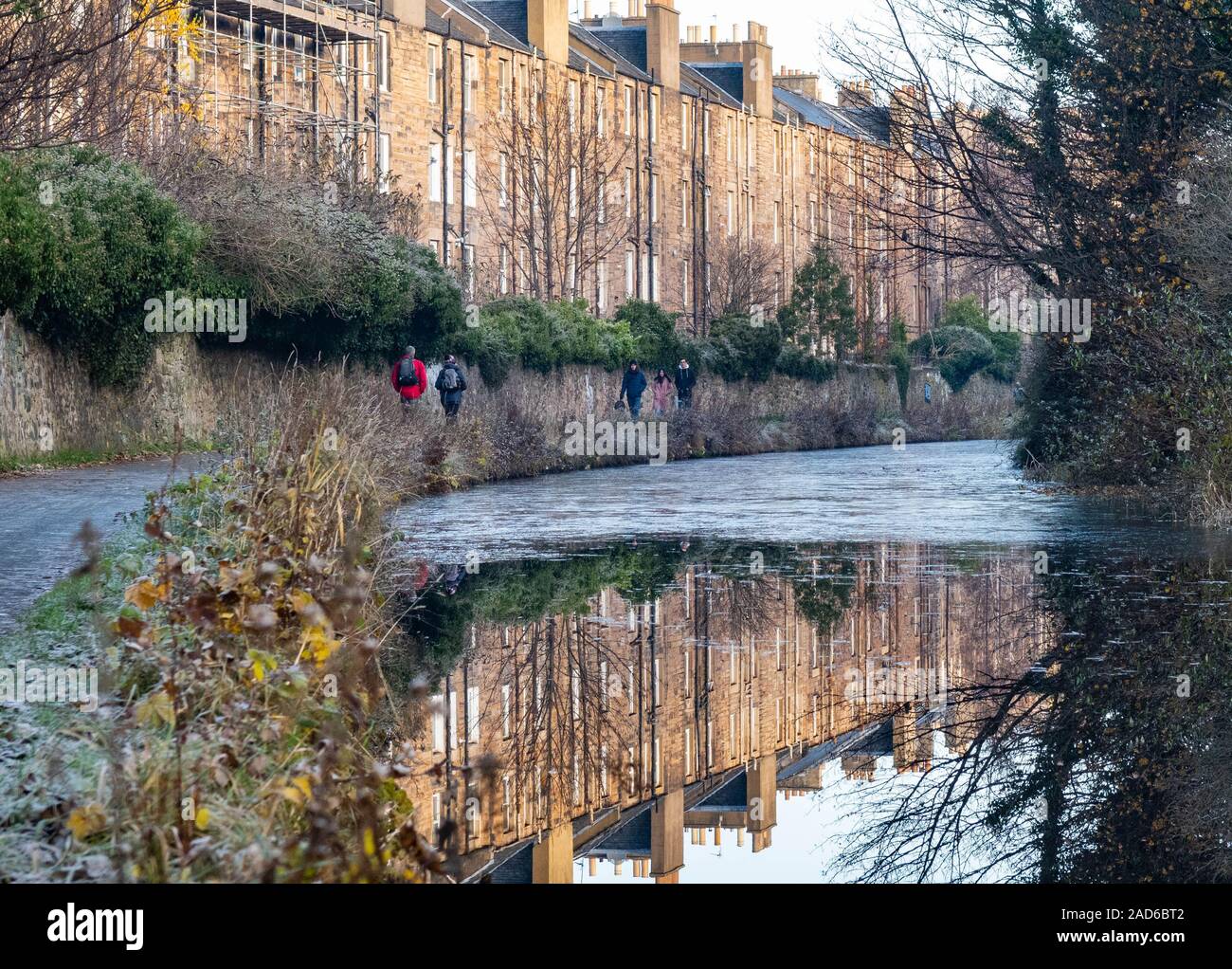La gente che camminava sul Union Canal alzaia sulla Strada Nazionale 754 passato tenement edifici, Polwarth, Edimburgo, Scozia, Regno Unito su un gelido inverno giorno Foto Stock