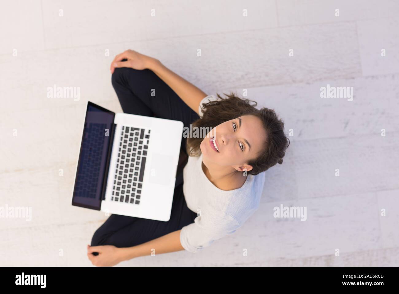 Le donne che usano il computer portatile sul pavimento vista superiore Foto Stock