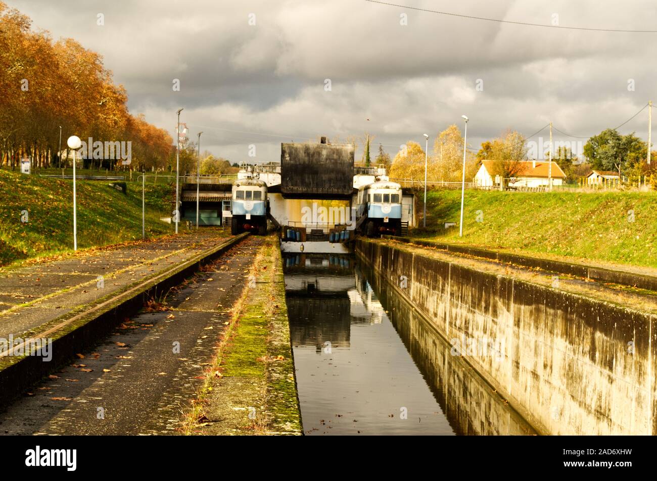 Il gemello di locomotori della Montech pendenza di acqua sul canale laterali con la gate di mobile in posizione sollevata e la barca spingere abbassato Foto Stock