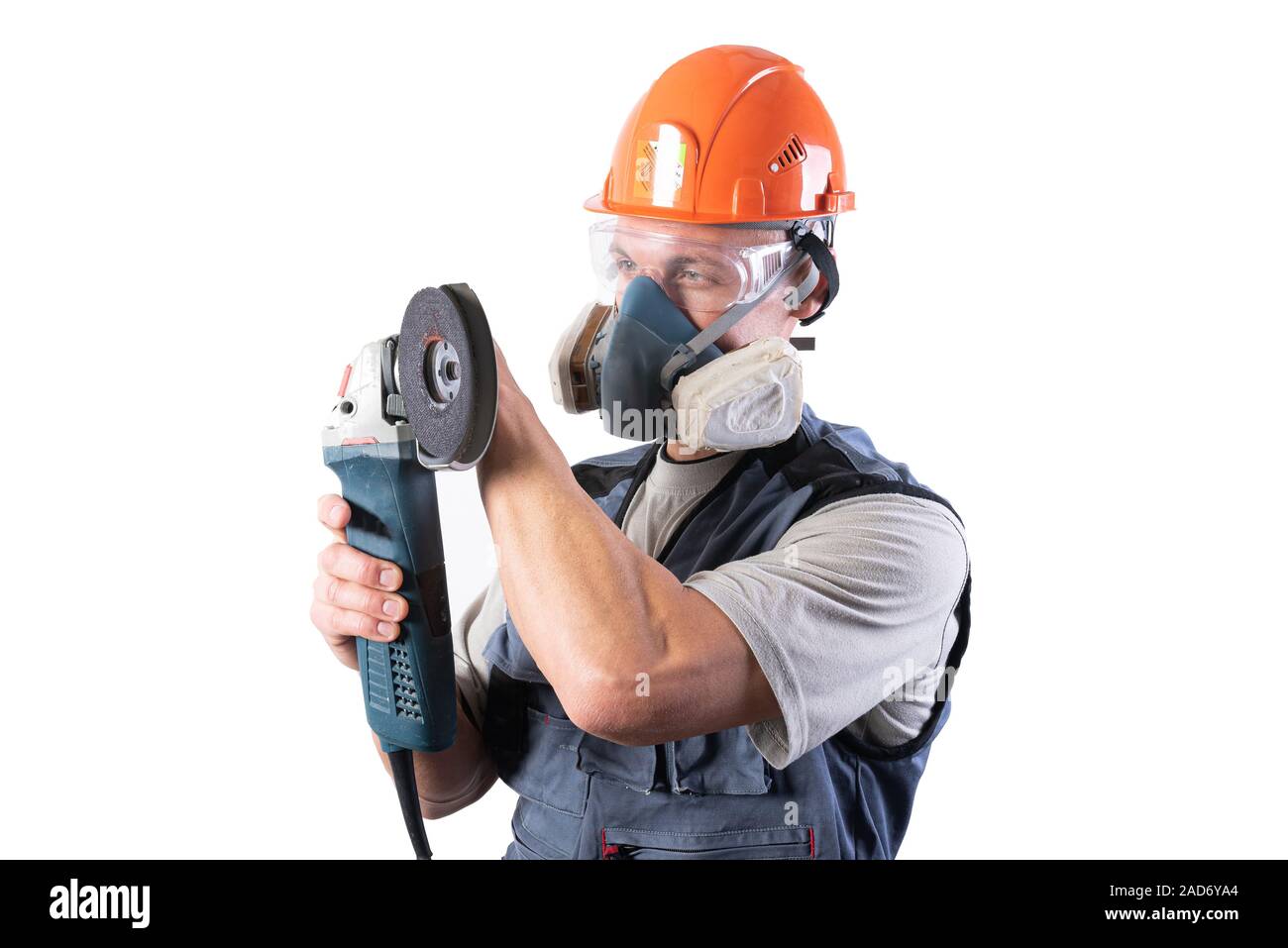 Builder in un casco e un respiratore, con una smerigliatrice angolare nelle sue mani. Foto Stock