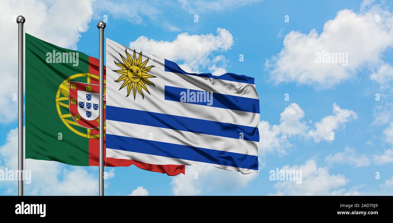 In Portogallo e in Uruguay bandiera sventolare nel vento contro bianco torbido cielo blu insieme. Concetto di Diplomazia e relazioni internazionali. Foto Stock