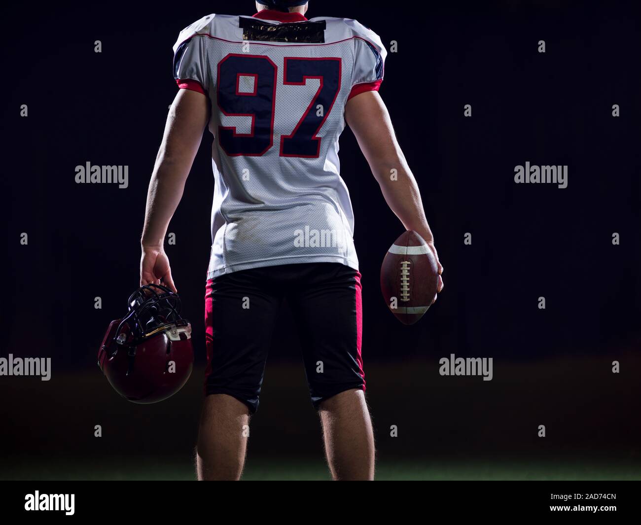 Vista posteriore del giovane fiducioso giocatore di football americano Foto Stock