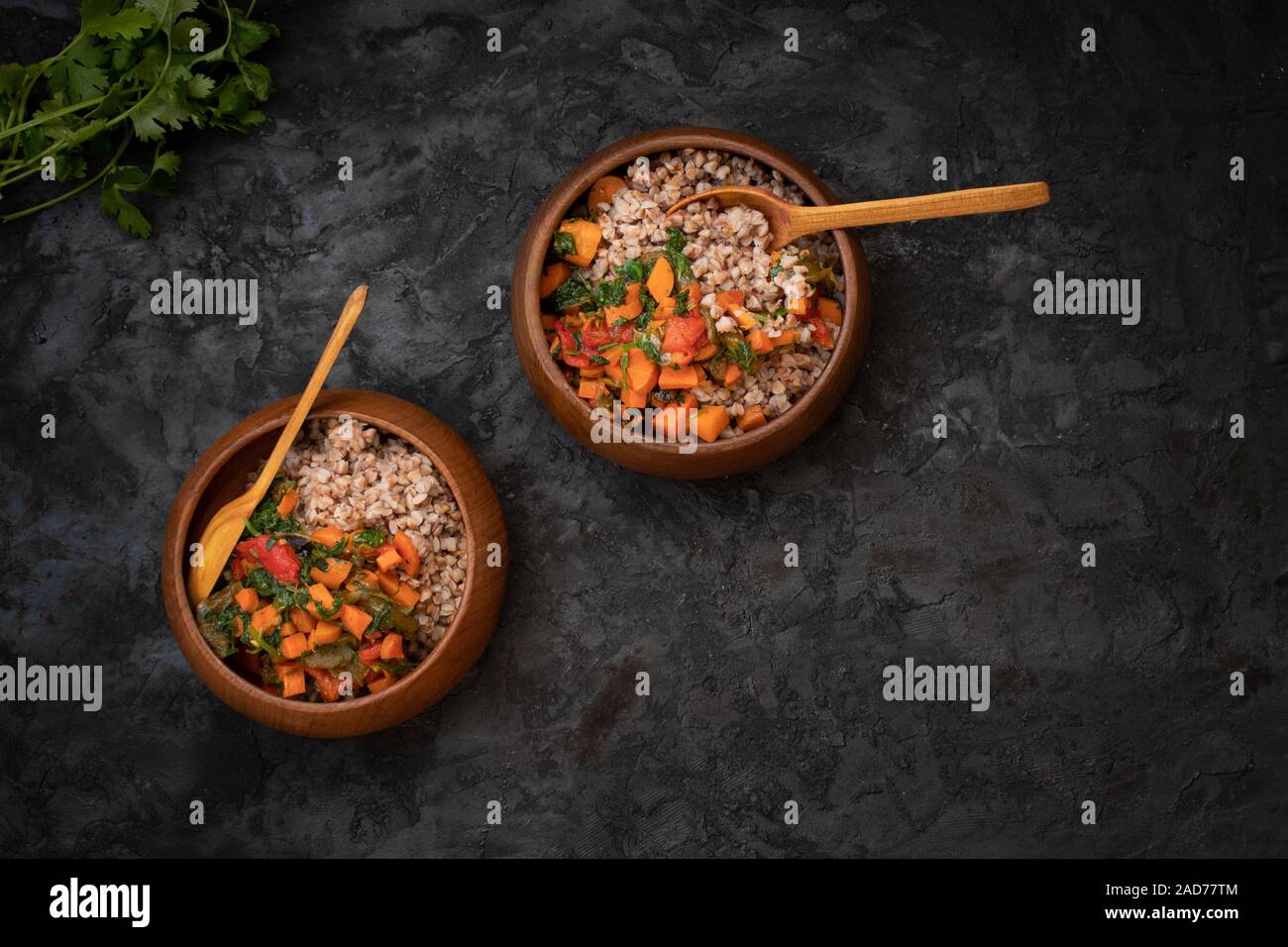 Vegano semole di grano saraceno cotto con la carota e bellpepper arrosto servita in ciotole di legno Foto Stock