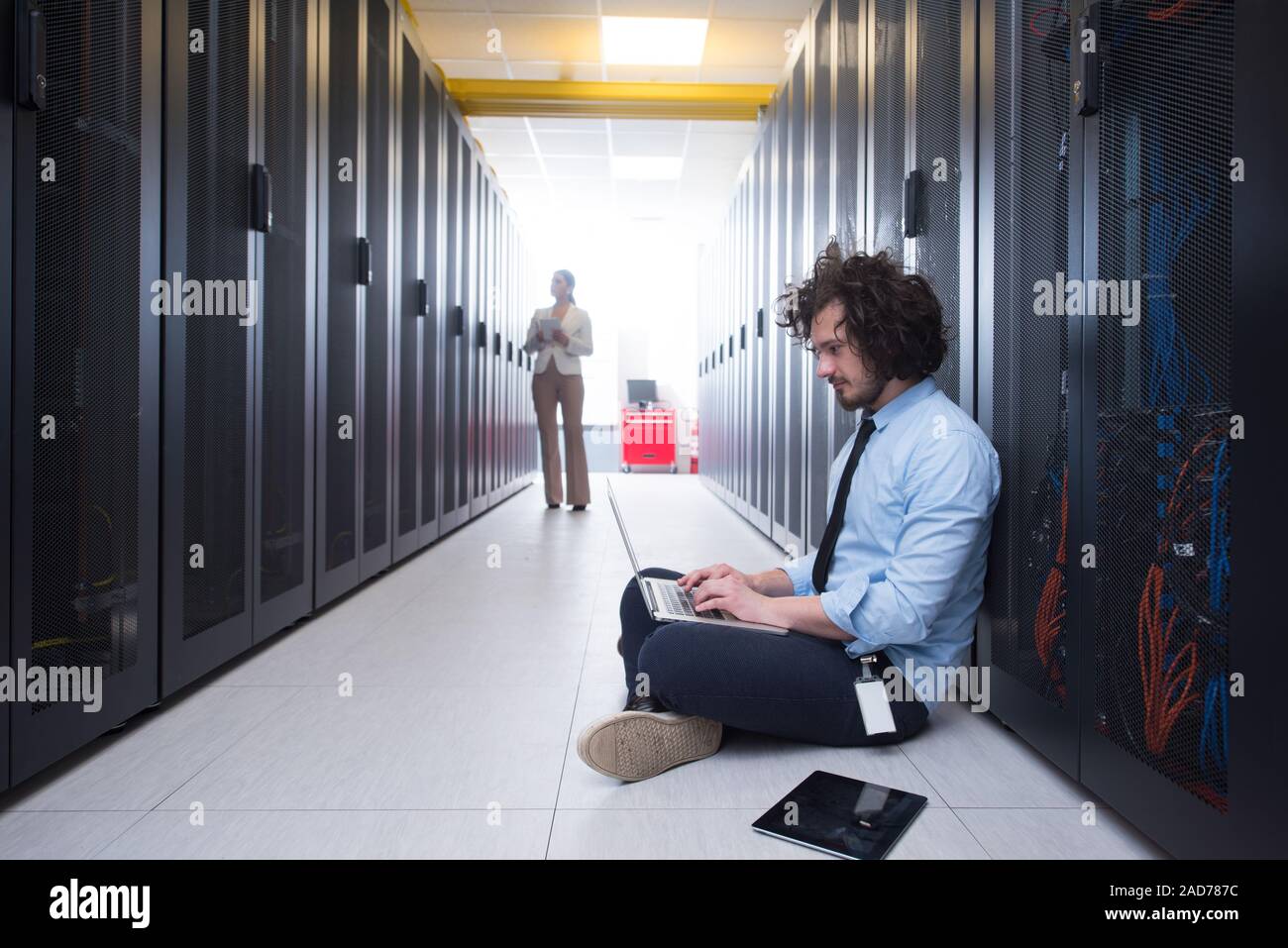 Team di giovani tecnici che lavorano insieme su server Foto Stock