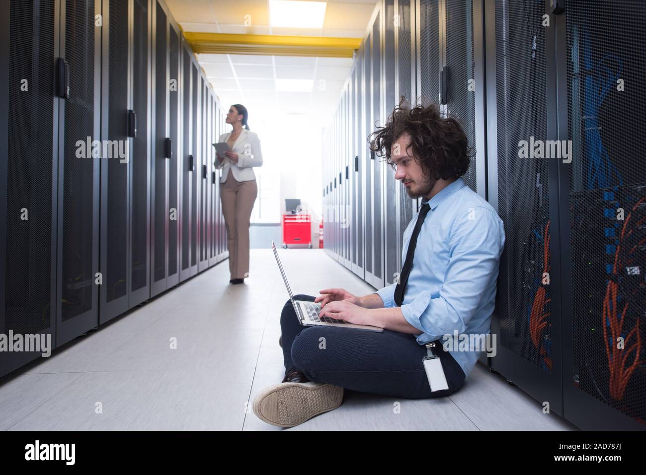 Team di giovani tecnici che lavorano insieme su server Foto Stock