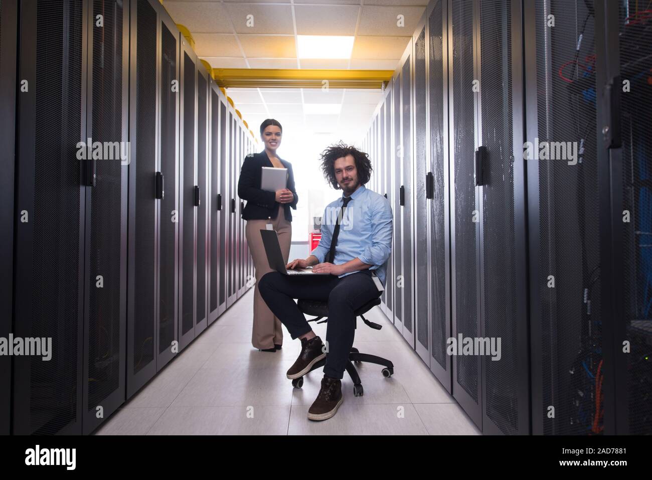 Team di giovani tecnici che lavorano insieme su server Foto Stock