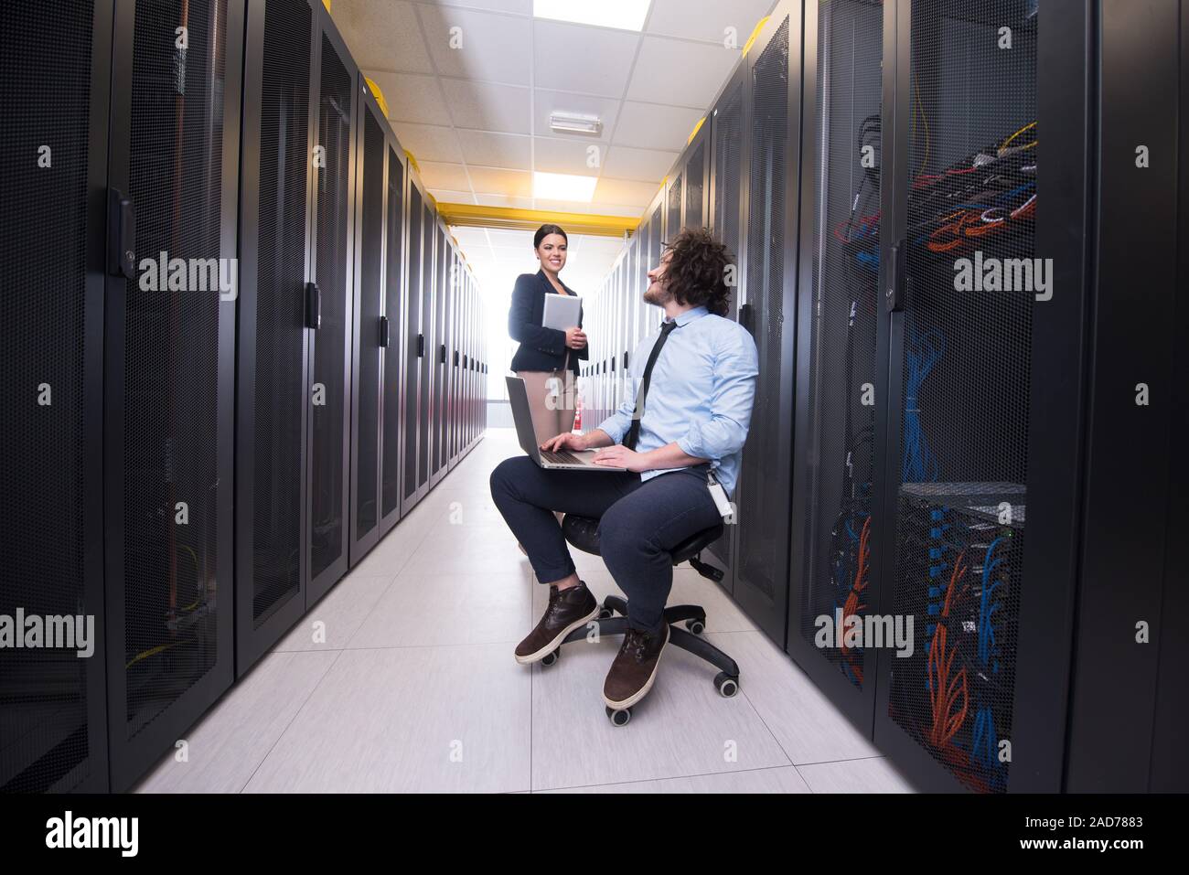 Team di giovani tecnici che lavorano insieme su server Foto Stock