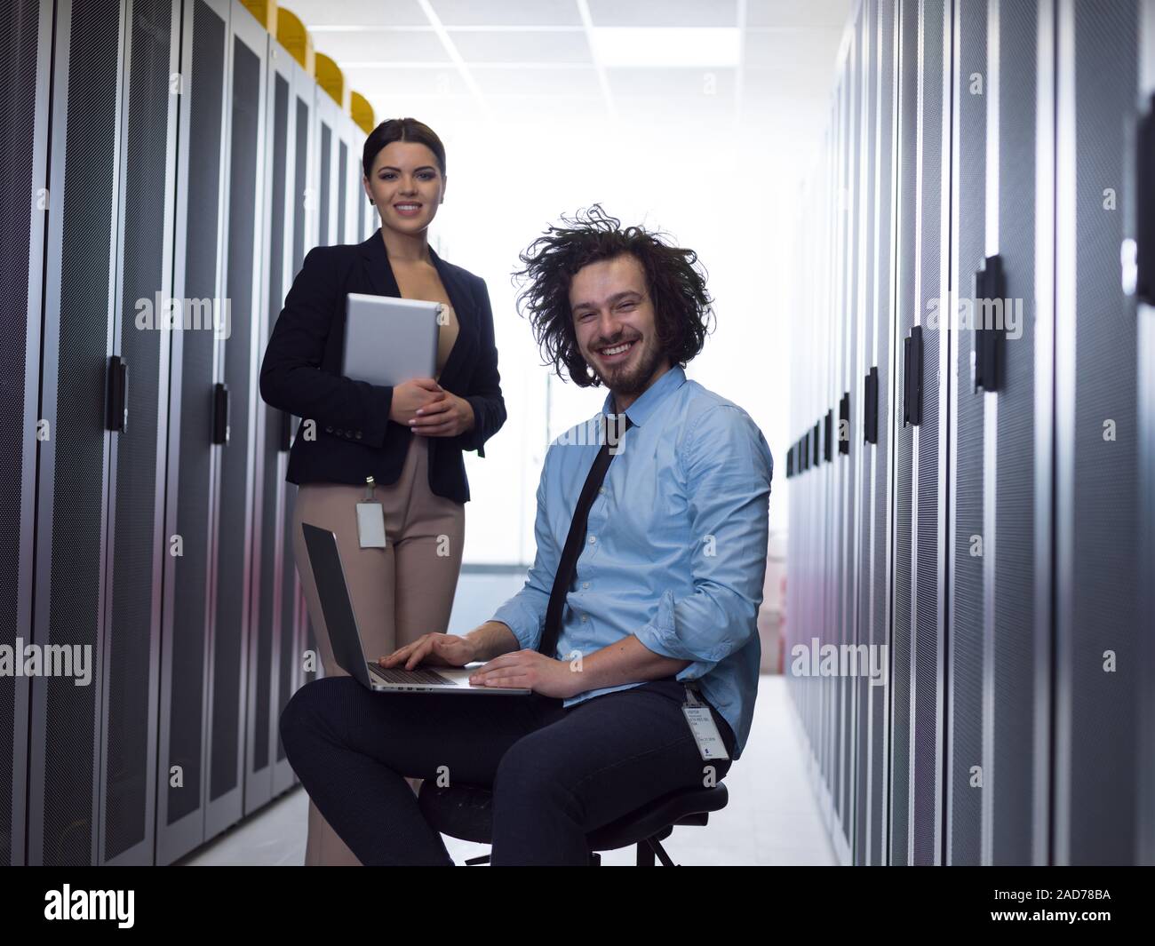 Team di giovani tecnici che lavorano insieme su server Foto Stock