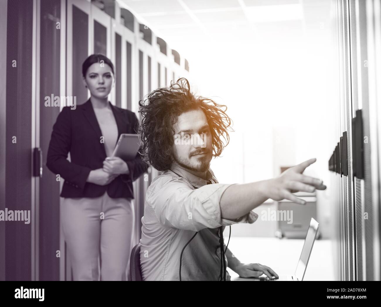 Team di giovani tecnici che lavorano insieme su server Foto Stock