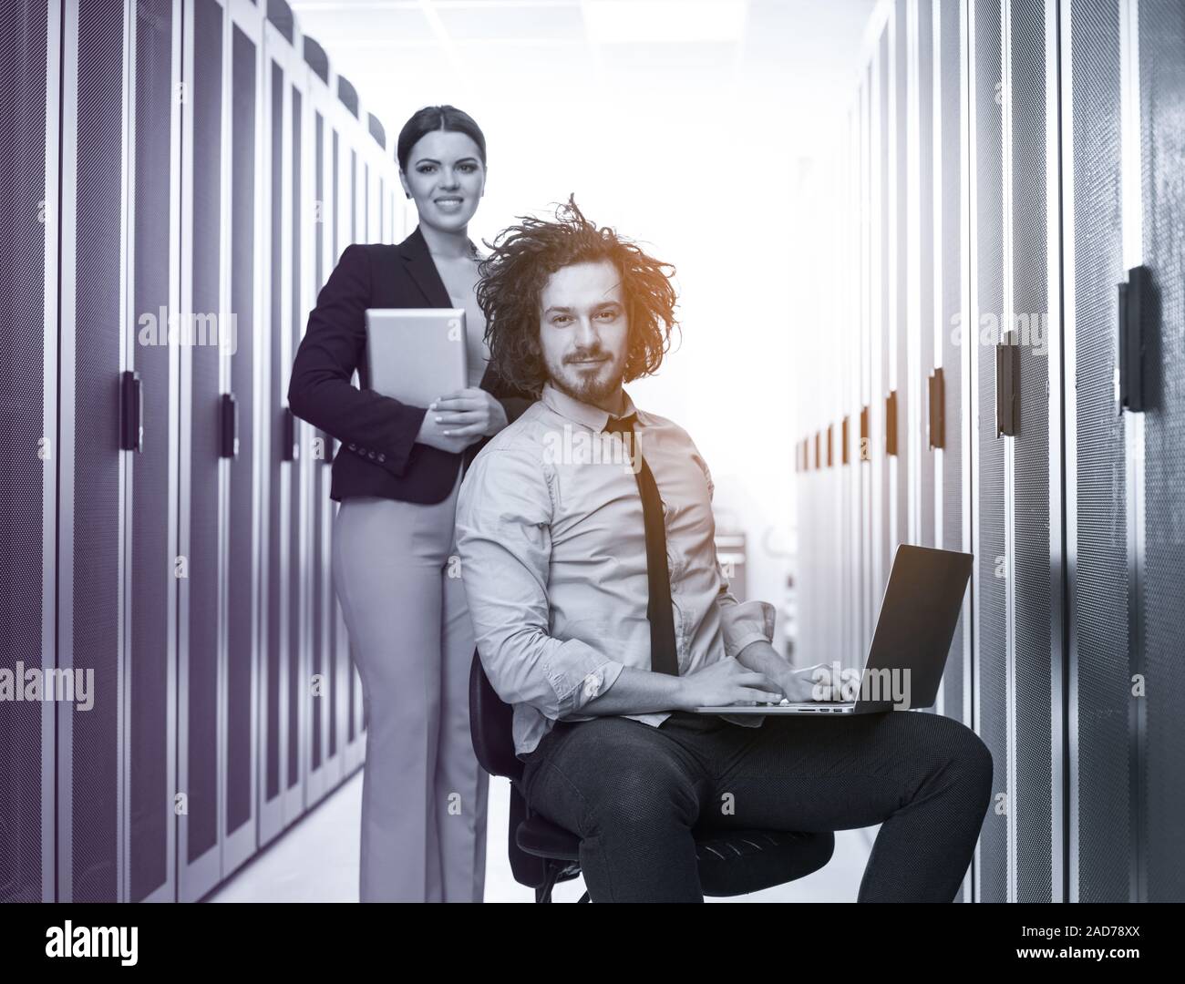 Team di giovani tecnici che lavorano insieme su server Foto Stock