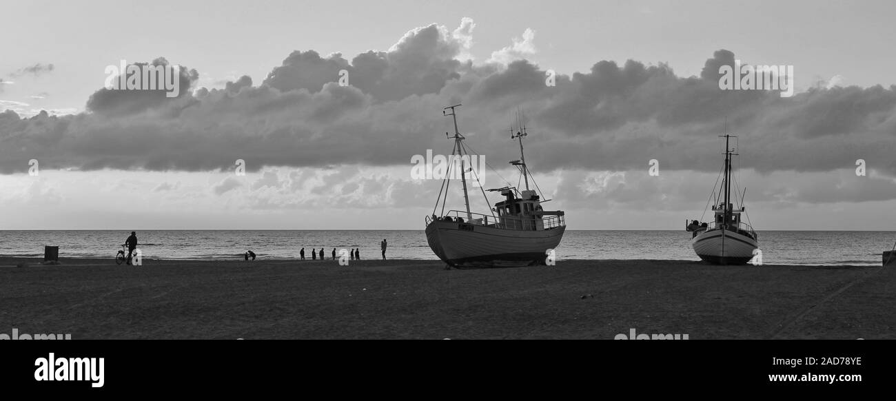Estate nuvole sopra il Jammerbugten, Danimarca. Spiaggia di scena a Slettestrand. Barche da pesca sulla riva. Foto Stock