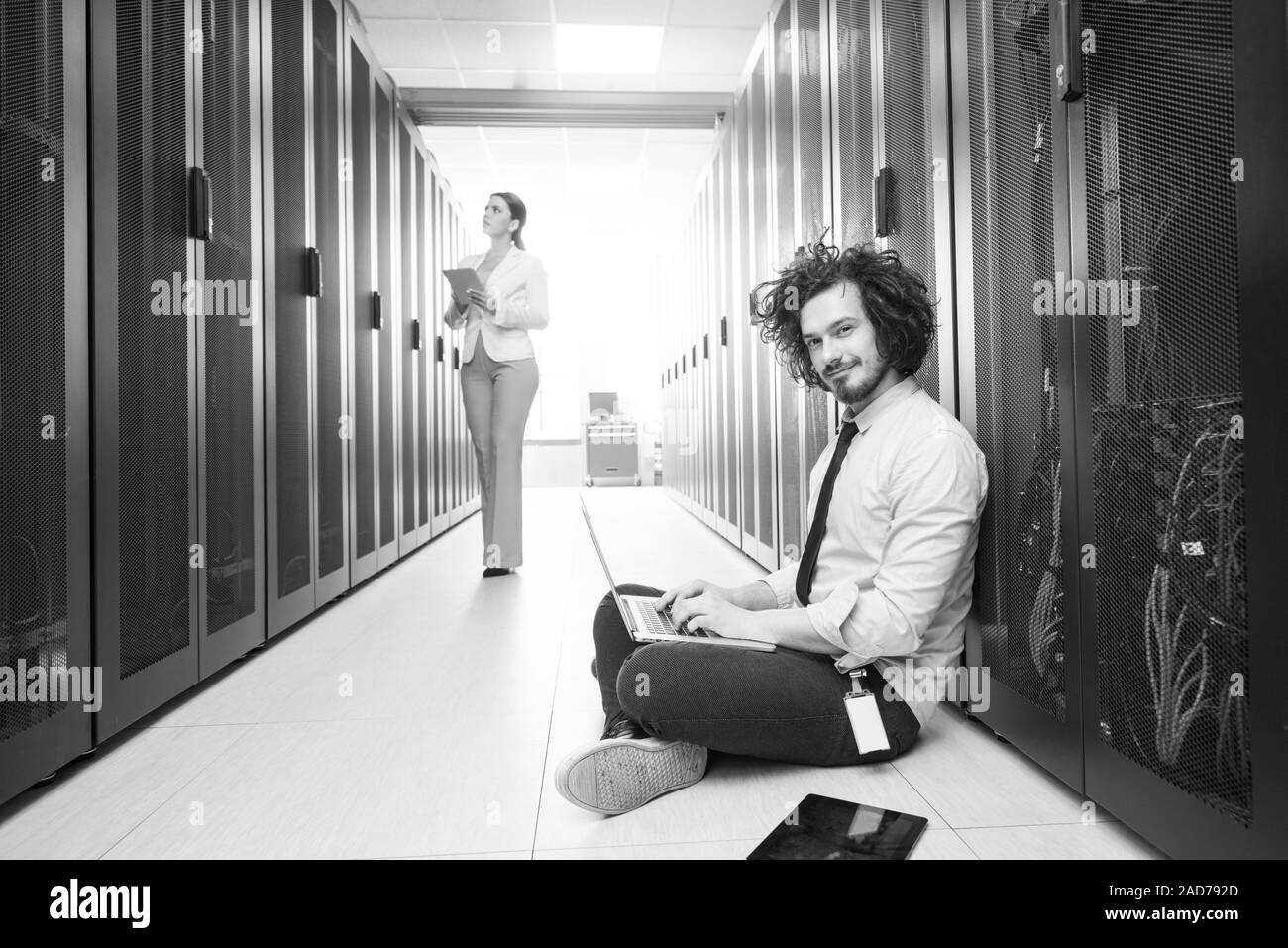 Team di giovani tecnici che lavorano insieme su server Foto Stock