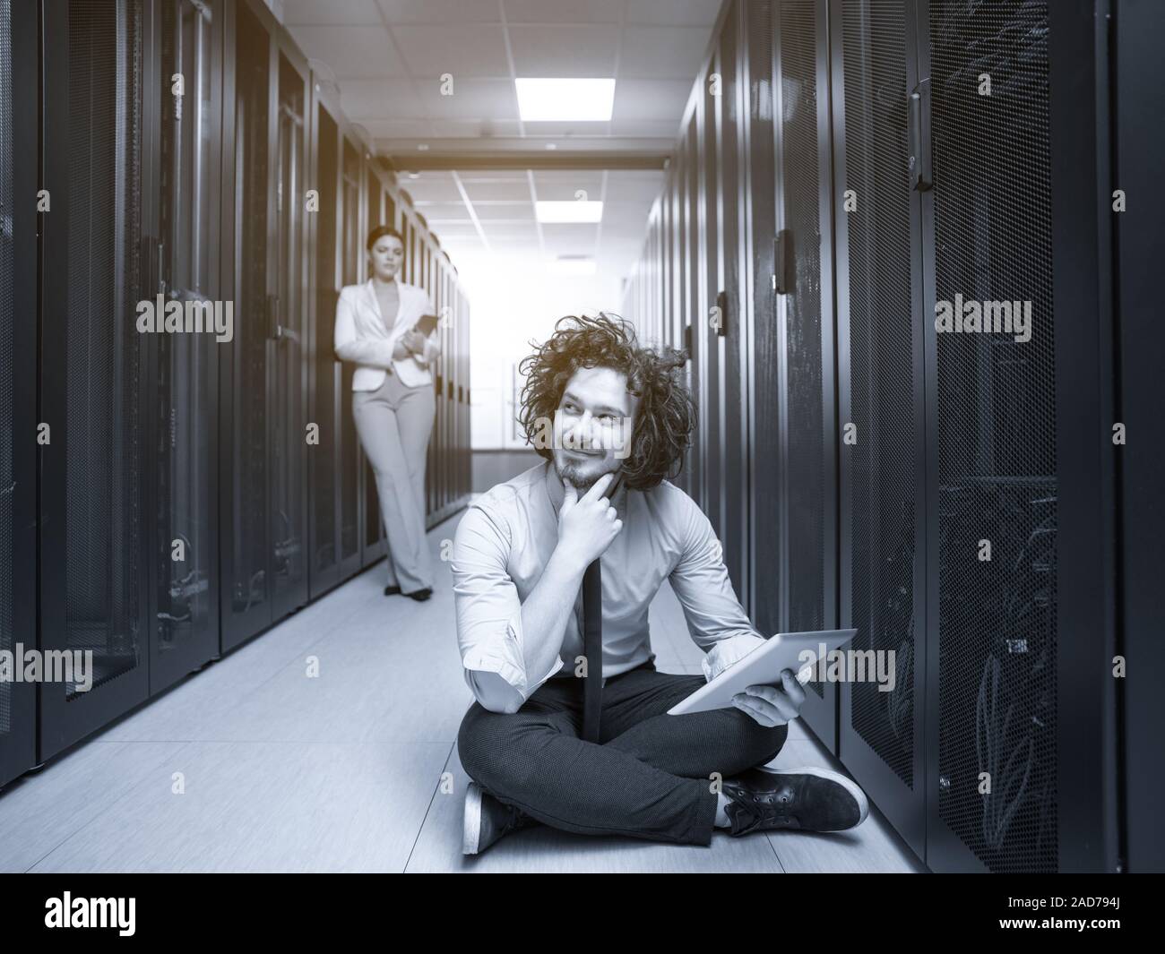 Giovani tecnici che lavorano insieme su server Foto Stock