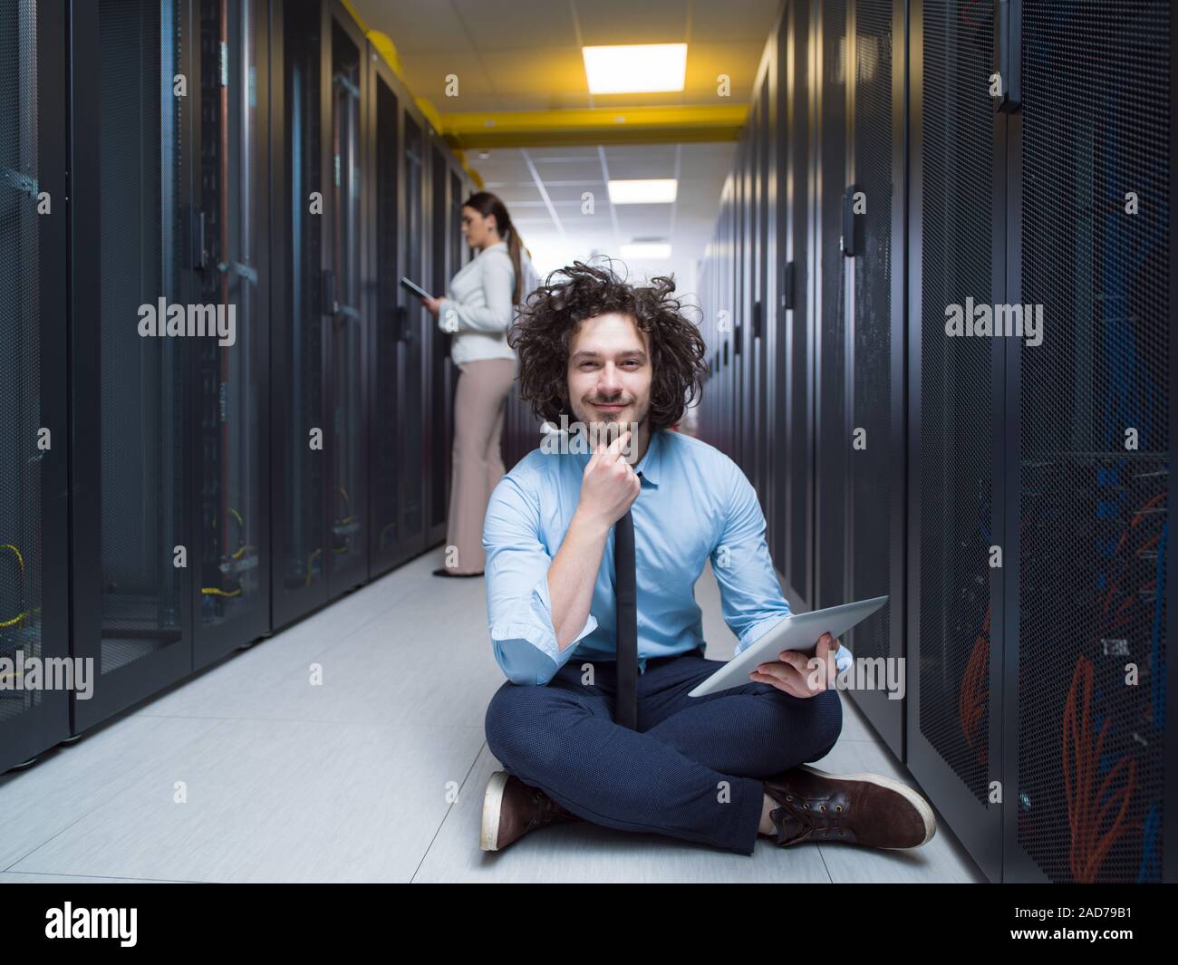 Giovani tecnici che lavorano insieme su server Foto Stock