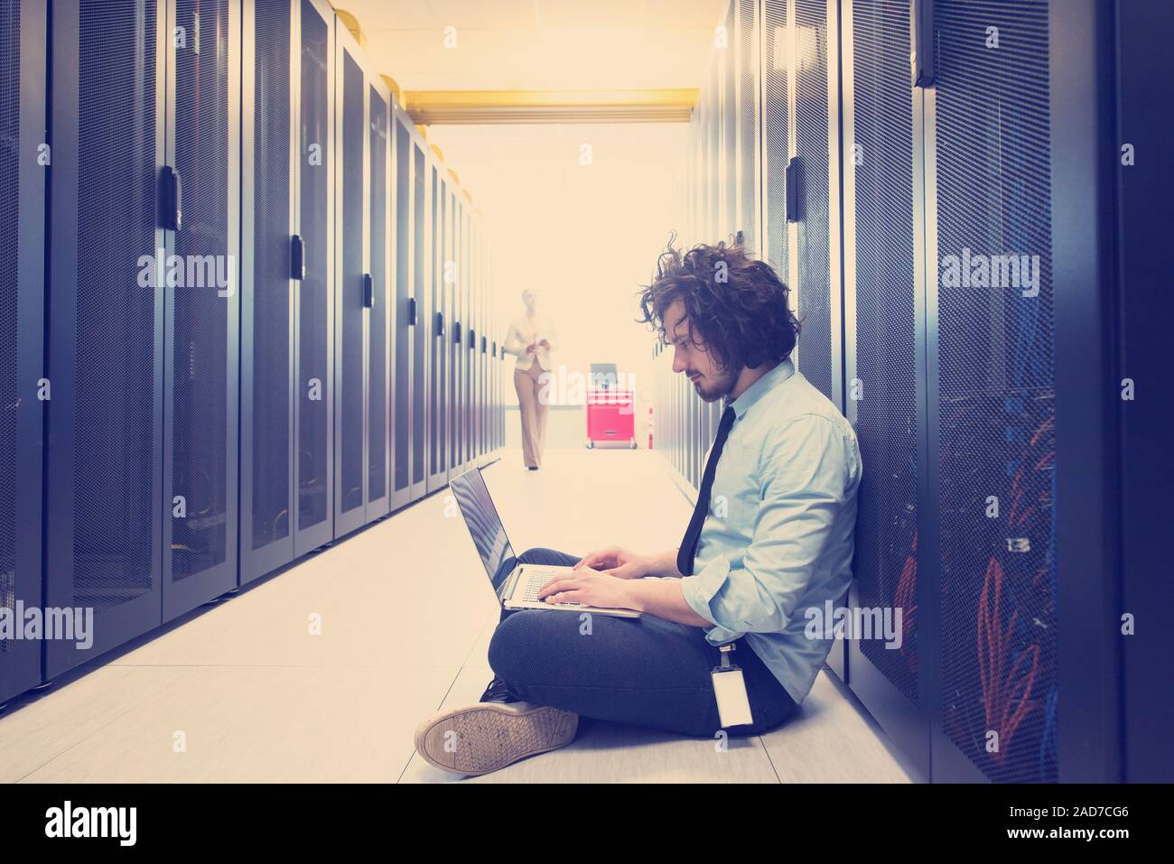 Team di giovani tecnici che lavorano insieme su server Foto Stock