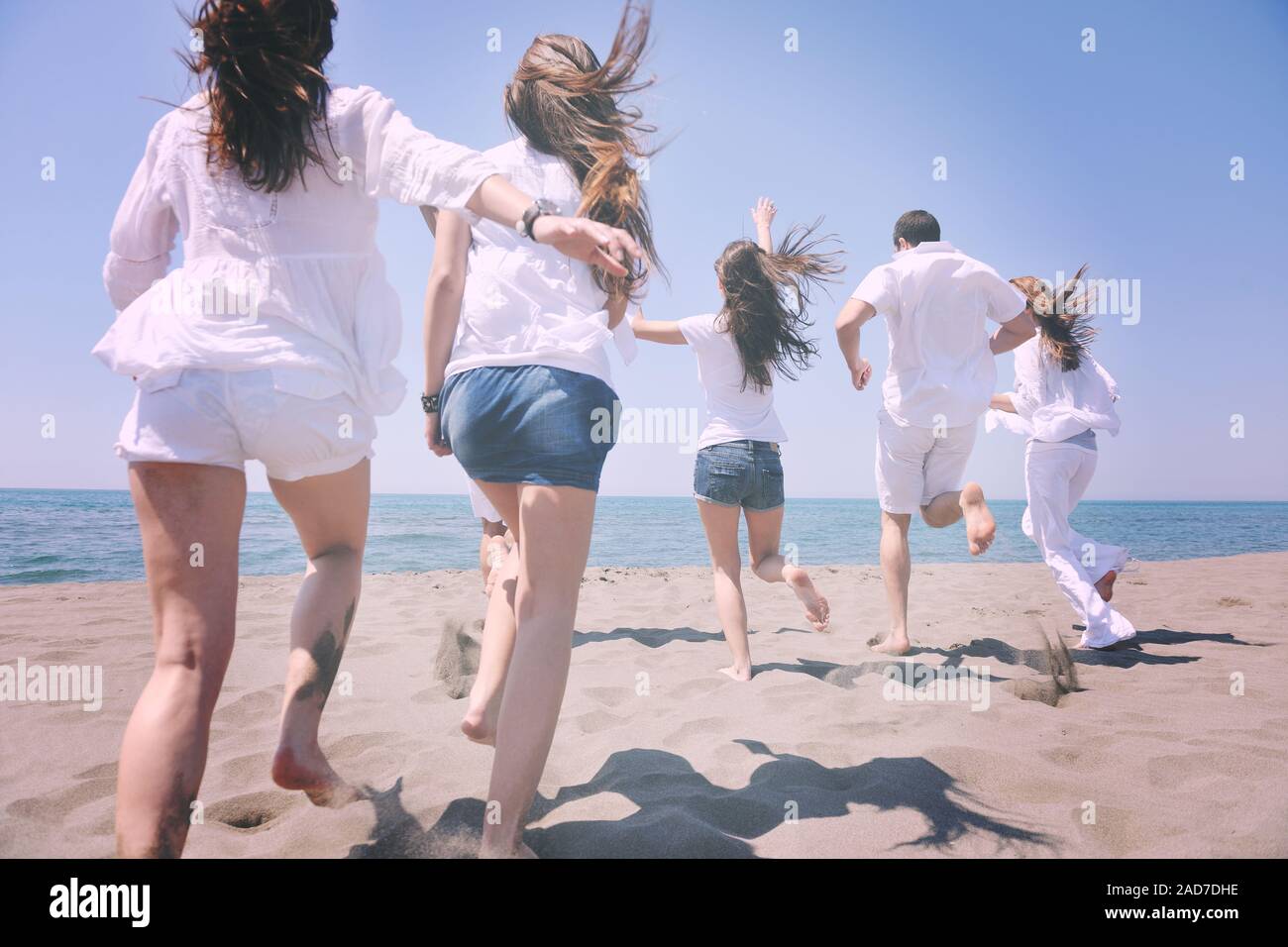 Le persone felici gruppo hanno divertimento e in esecuzione sulla spiaggia Foto Stock