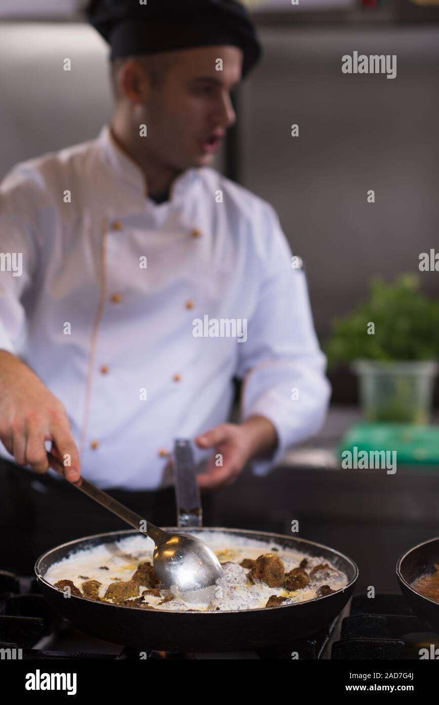 Lo chef prepara cibi, frittura in padella wok Foto Stock